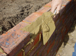 Surplus cement mortar being taken off with bricklaying trowel